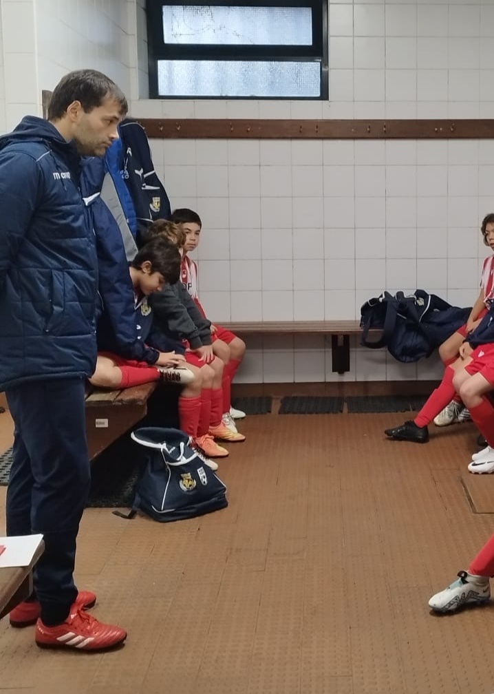 Treinador e jovens atletas num balneário antes de um jogo