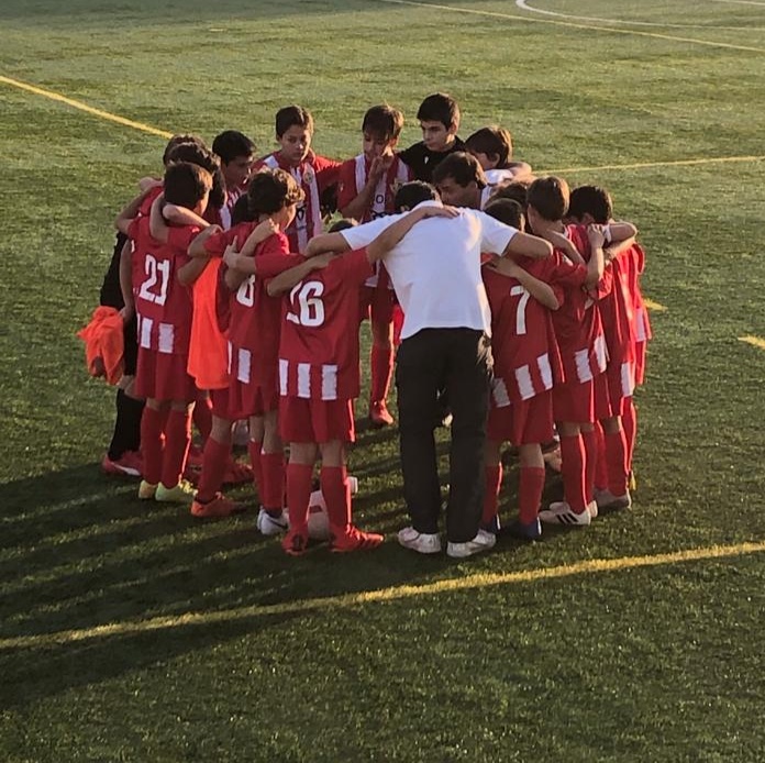Equipa de futebol reunida em círculo no campo